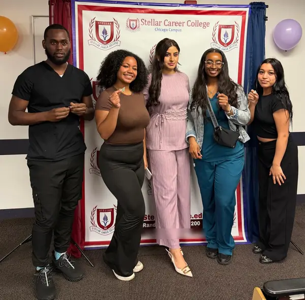 Alina Asif with new students holding up their pins at a meet and greet, Stellar Career College Chicago campus